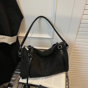 Primo piano della borsa tote in pelle scamosciata nera opaca su libri d'epoca