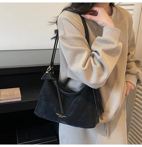 Détail du sac bandoulière noir mat avec lettrage doré et bandoulière réglable pratique