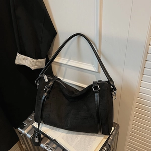 Dettaglio borsa tote in pelle scamosciata nera con tracolla e dettagli in argento