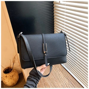 Detailed close-up of a black lychee texture leather shoulder bag with silver U-shaped clasp