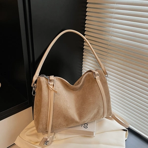 Dettaglio borsa tote in pelle scamosciata color cammello con spalline in pelle e lucchetto