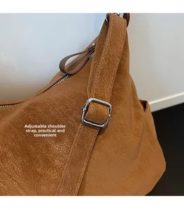 Détail de la bandoulière réglable et du cuir marron texturé sur le sac cabas épuré