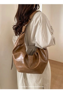 Grand sac Hobo marron en cuir plissé présenté dans un contexte de style de vie chic
