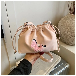 Pink drawstring bucket bag featuring a detailed plush pony embroidery and fine leather texture
