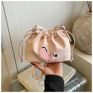 Detail of light pink drawstring cloud bag with plush horse embroidery and soft PU texture