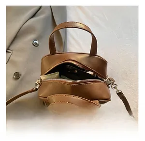 Macro detail showing interior storage capacity of a vintage brown mini crossbody bag