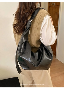 Détail du sac bandoulière minimaliste en similicuir noir avec bandoulière large