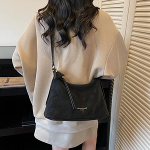 Sac hobo minimaliste en cuir noir en forme de croissant avec logo doré