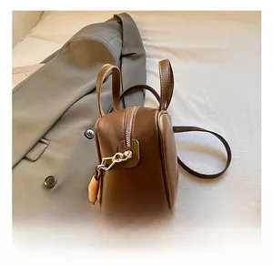 Detailed side view of dark brown leather mini bag with silver metal zipper and slim strap