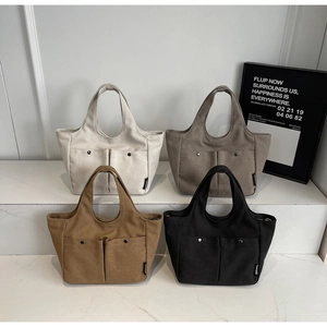Minimalist canvas tote bags displayed in multiple colors showing texture and pocket details
