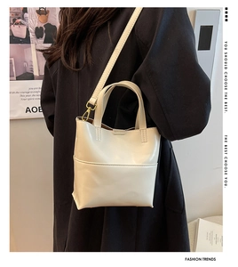 Dettaglio della borsa tote color crema in PU con tasca frontale e tracolla su modella