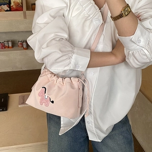Detail of pink drawstring bucket bag with cute embroidered puppy and slim strap
