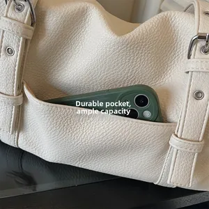 Macro view of durable exterior pocket on cream leather tote with smartphone inside