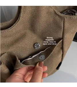 Detail view of the strong magnetic closure and striped lining on brown canvas tote bag