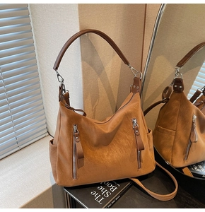 Détail du sac hobo en similicuir marron avec fermetures éclair et poches latérales
