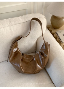 Gros plan d'un sac hobo marron texturé avec fermeture éclair dans un décor cosy