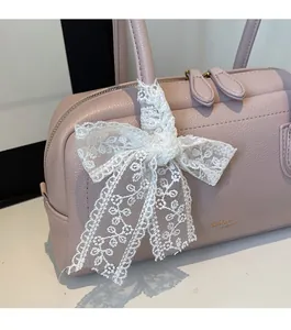 Detail of lavender litchi leather bag with white lace floral bow and double zipper