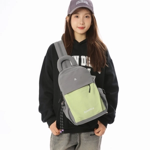 Detailed close-up of a neutral crossbody chest bag with grey and light green panels