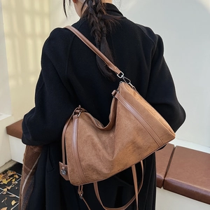 Dettaglio della borsa hobo in camoscio marrone con trama morbida e tracolla sottile