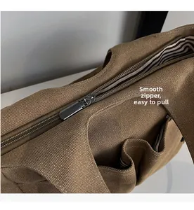 Detail view of the smooth gunmetal zipper and striped fabric lining on brown canvas bag