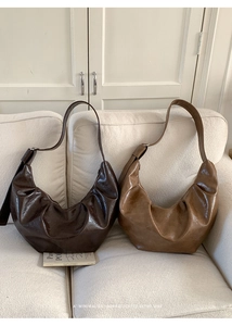 Détail de la texture en cuir verni plissé brillant sur ces sacs hobo rétro demi-lune