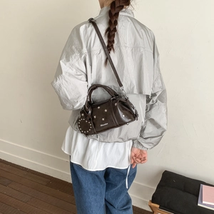 Dunkelbraune Boston-Tasche mit silbernen Sternennieten als Umhängetasche am Model