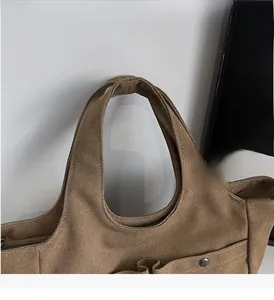 Close-up of durable canvas tote handle with reinforced double stitching in brown