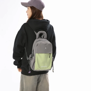 Detail of grey and neon green fashion backpack showing the side drawstring and ring handle