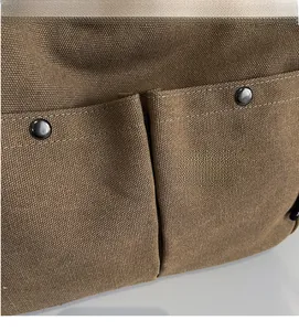 Detail of brown canvas bag with thick woven texture and black metal snap buttons