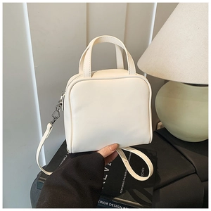 Detailed macro view of the cream white retro satchel bag with silver hardware and smooth finish