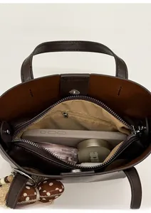 Vue de dessus d'un sac seau en cuir marron montrant les compartiments et la capacité interne
