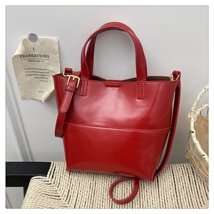 Dettaglio della borsa tote in pelle PU rossa con dettagli dorati e tracolla regolabile