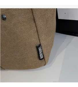 Close-up of durable canvas fabric with vintage metal snap and side brand label detail
