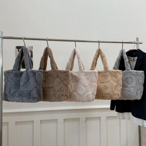 Detailed macro view of geometric embossed patterns on colorful plush faux fur tote bags