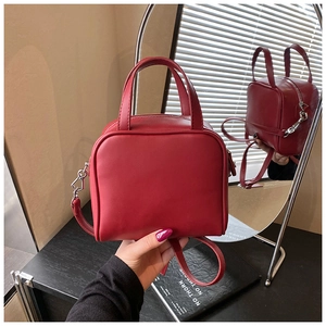 Detailed view of burgundy PU leather mini bag with silver hardware and dual handles