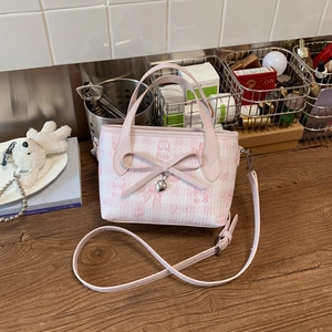 Pink printed large tote bag with cute cat bow patterns and heart pendant shown on a table