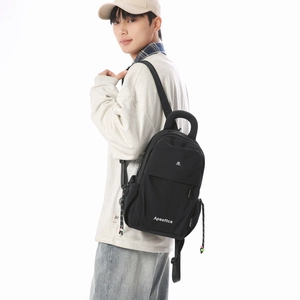 Side view of a black lightweight casual backpack with white brand logo worn by a model