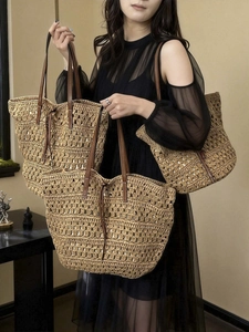 Large hand-woven straw tote bag with brown leather straps for summer beach vacations