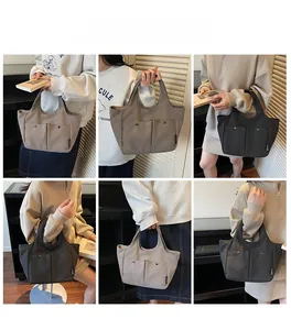 Detail view of large canvas tote bag showing front pockets, metal snaps, and diverse colors