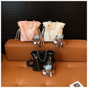 Detailed view of quilted bucket bags with gold chains and cute bear charms in three colors