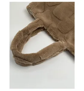 Detail of thickened brown plush handle on a checkered faux fur tote bag with soft inner lining