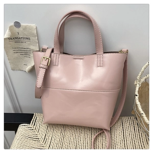 Dettaglio della borsa rosa in finta pelle su una sedia intrecciata in ambiente interno