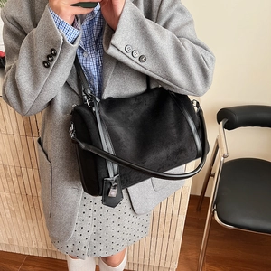 Dettaglio della borsa tote in pelle scamosciata nera con lucchetto d'argento e finiture