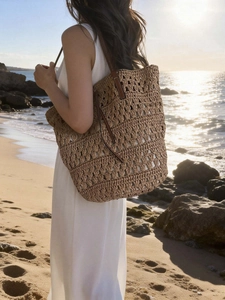 Large woven straw tote bag with brown leather handles for beach vacations and daily commute