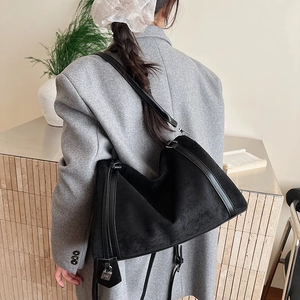 Dettaglio borsa hobo in pelle scamosciata nera con finiture in pelle e ciondolo lucchetto