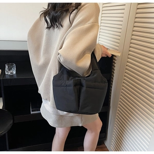 Detail view showing black quilted puffy tote bag with side pockets for daily commuting