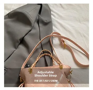 Detail of pink quilted handbag with gold chain handle and adjustable leather strap