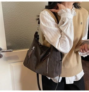 Vue détaillée d'un grand sac cabas marron foncé avec fermetures éclair et texture cuir rétro