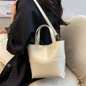 Dettaglio della mini borsa tote color crema in pelle PU con cuciture e tracolla regolabile