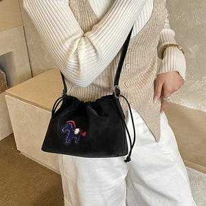 Detail of black drawstring bucket bag with colorful horse embroidery and slim strap